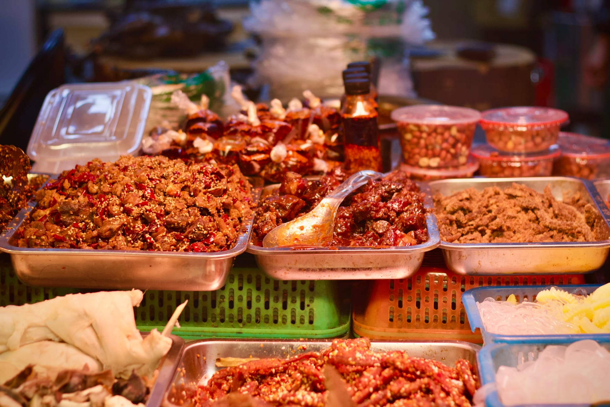 A street market stall in Luzhou covered in trays with mala spice covered meats.