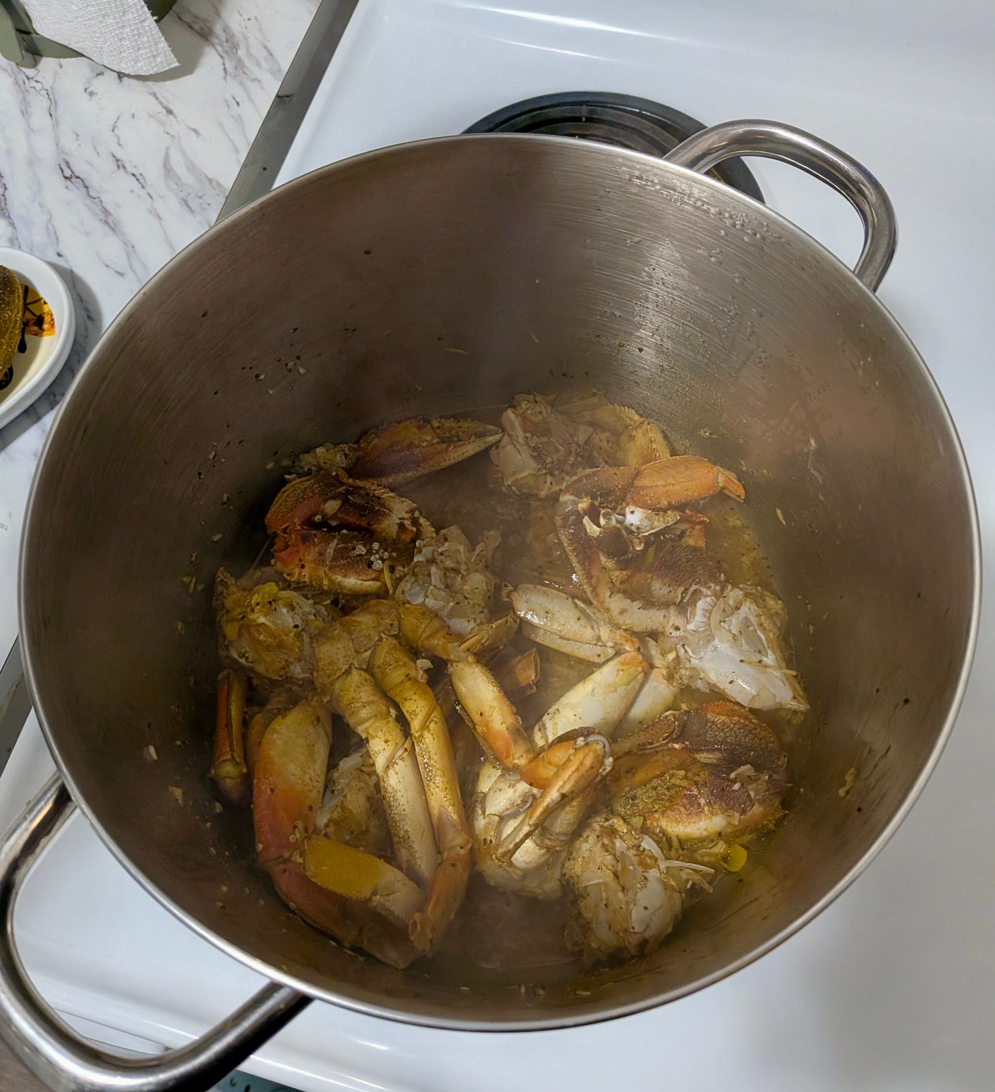 A stainless steel pot filled with seasoned crab meat.