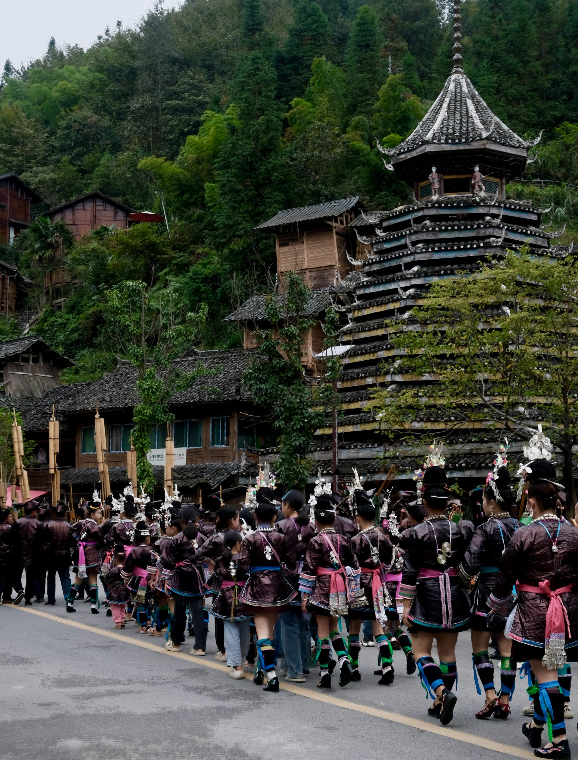 Dong women dressed in traditional outfits parade down the main street towards the rice fields where the Xianghe ritual takes place.