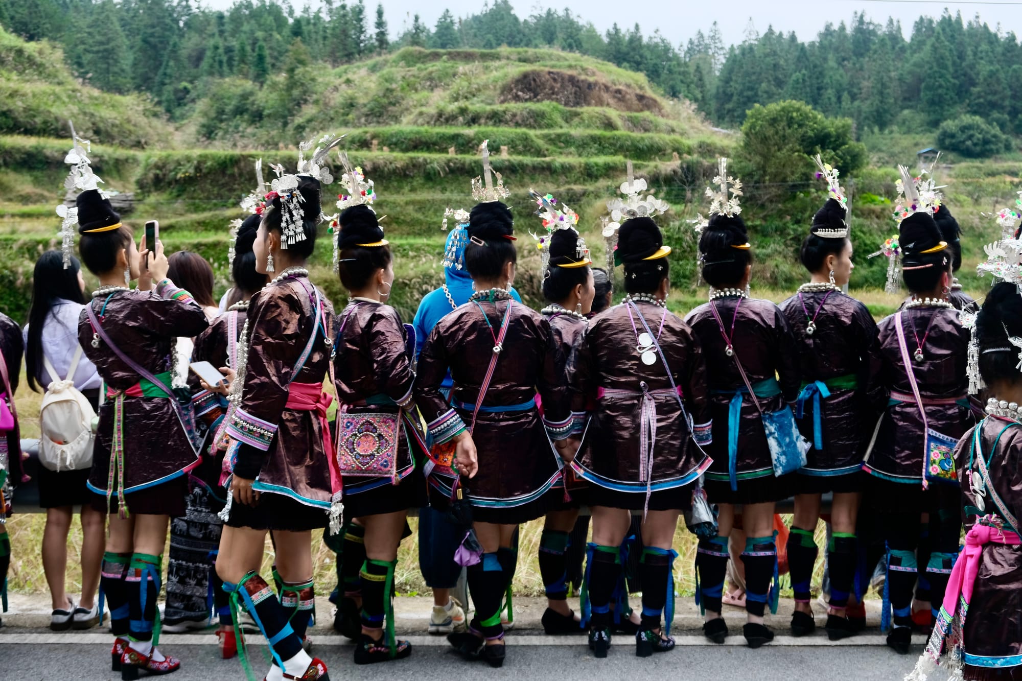 Dong women gather along the edge of the rice field to watch the men catch fish from the rice fields.