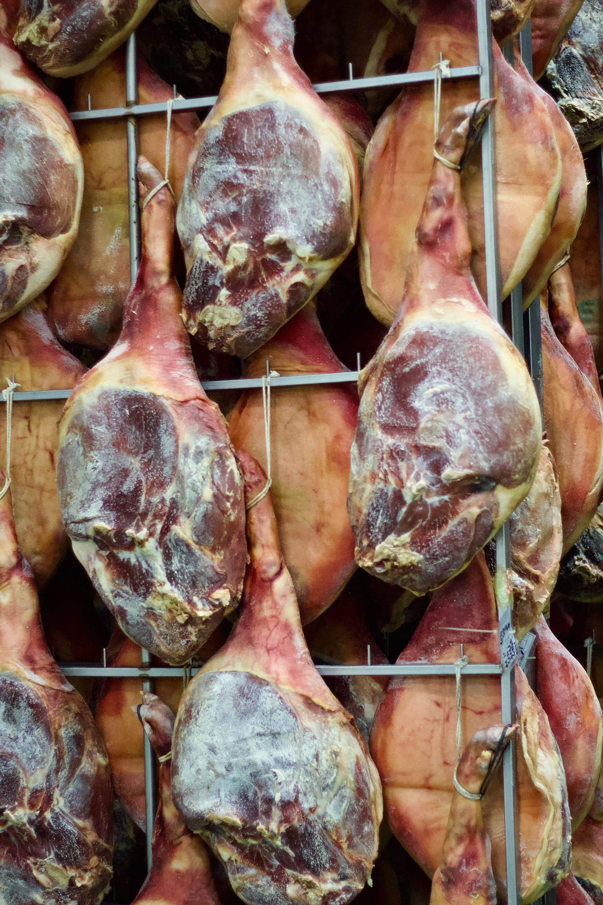Shanks of ham hang, drying.