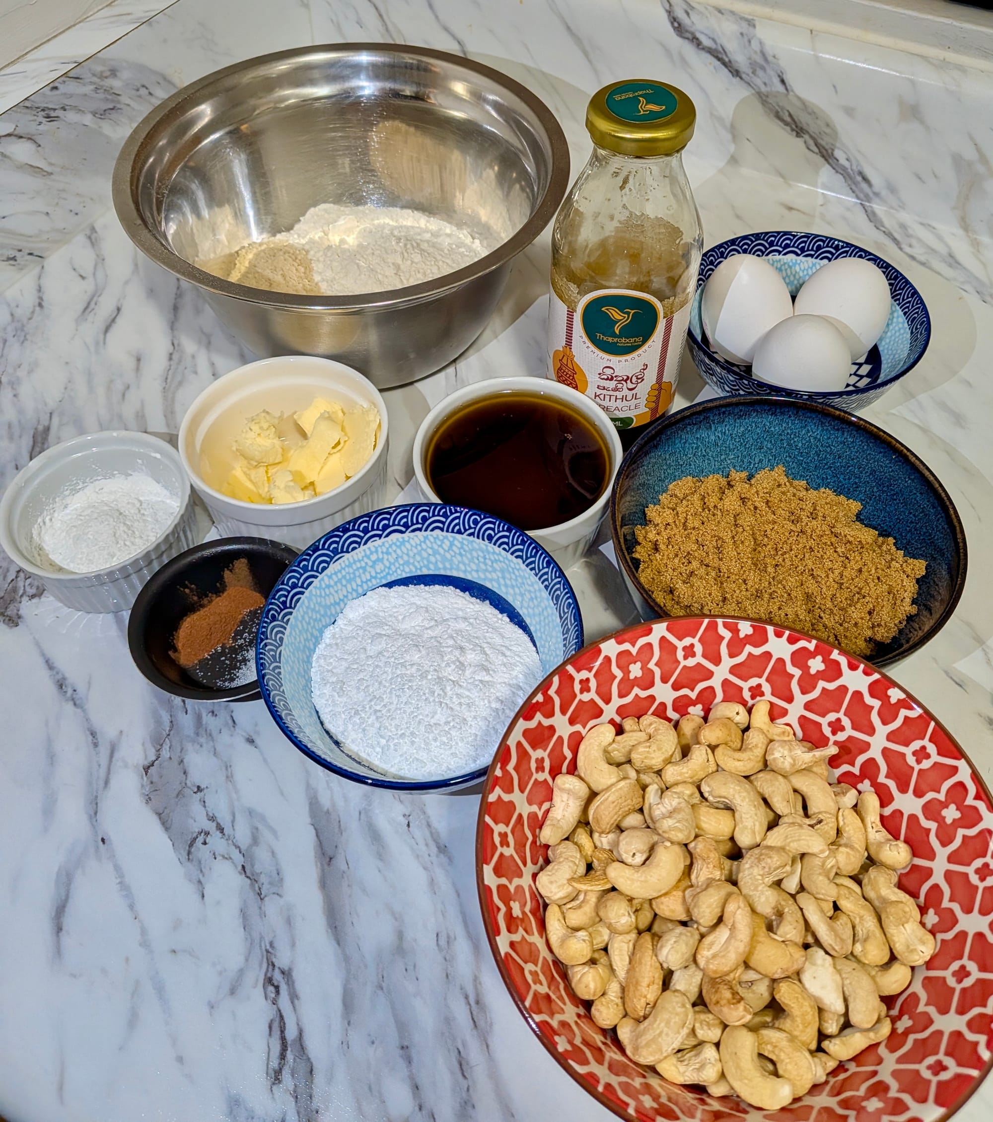 Ingredients portioned and sorted into bowls and dishes on a countertop for Cashew Nut and Kithul Treacle Tart