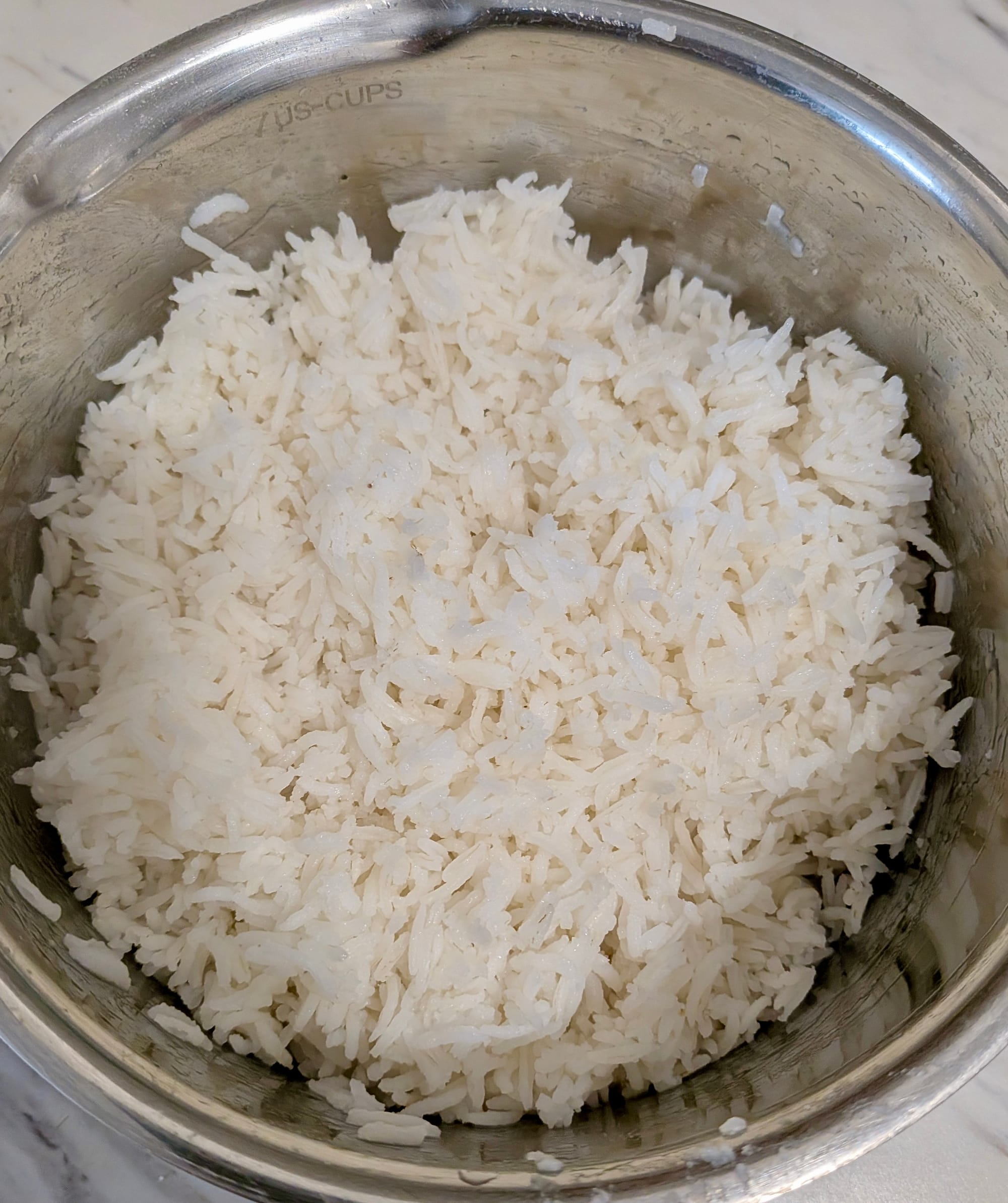 Left over white jasmine rice in a stainless steel bowl.