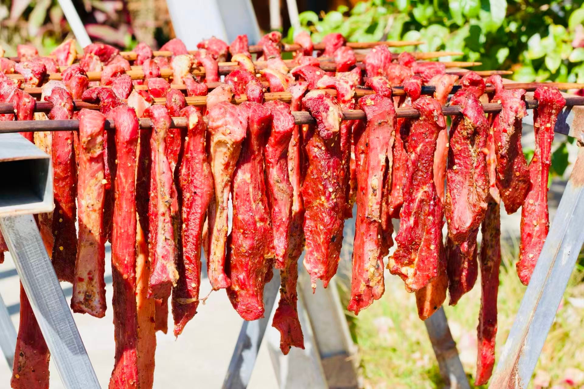 Beef shanks drying on racks in the sun.