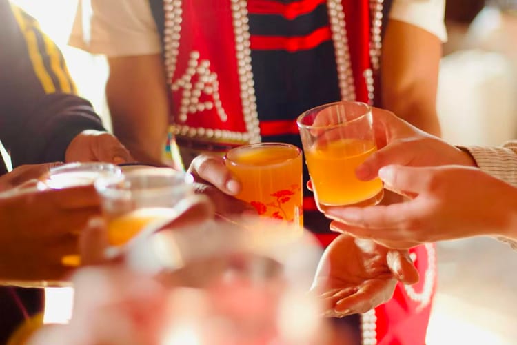 Hands holding water wine at a wedding ceremony.